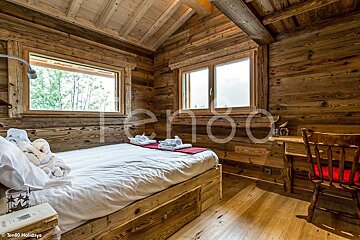 A bedroom with a bed and a desk with the word ten80 on the wall