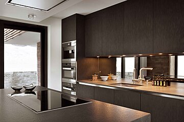 A kitchen with stainless steel appliances and black cabinets