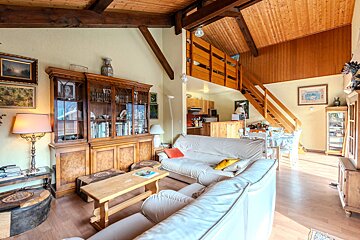 A living room with a staircase leading to the second floor