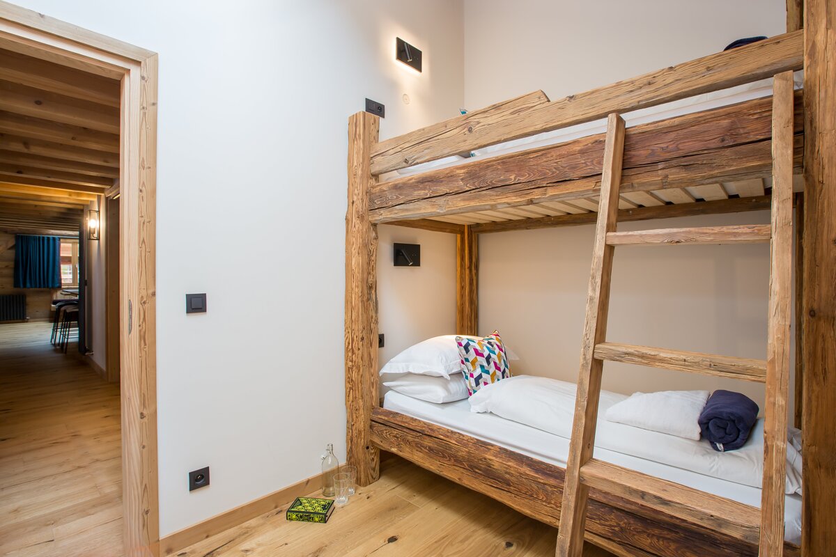 A bunk bed in a room with a book on the floor