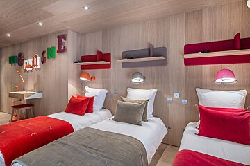 A bedroom with two beds and a wall with the letter e on it