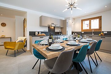 A dining room table with a bottle of wine on it