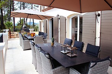A patio with a table and chairs under umbrellas