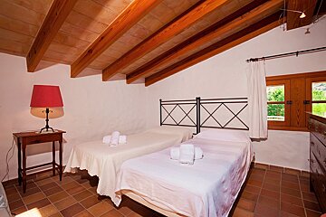 A bedroom with two beds and a red lamp