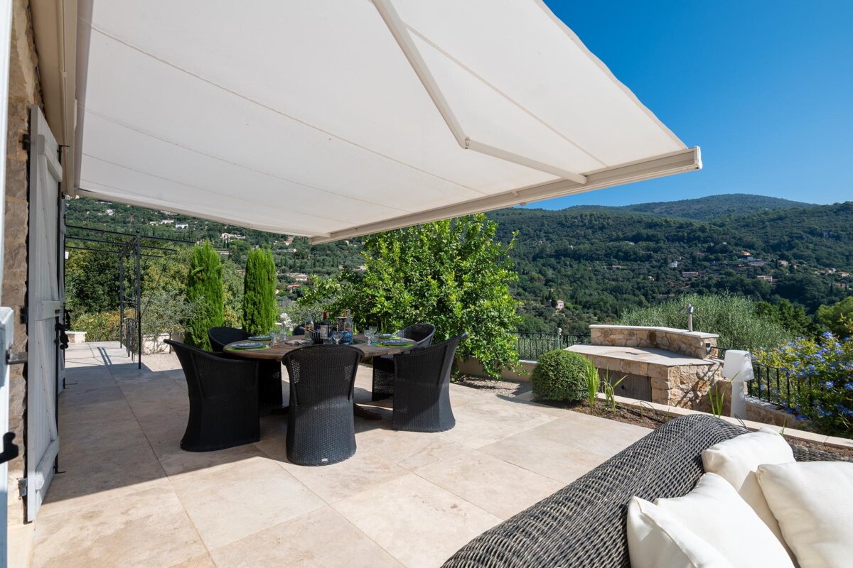 A patio with a table and chairs under an awning