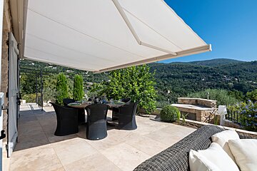 A patio with a table and chairs under an awning