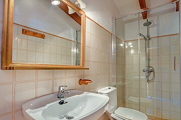 A bathroom with a toilet a sink and a mirror