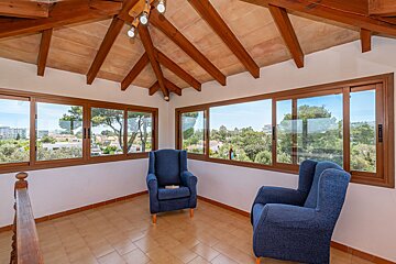 Two blue chairs in a room with a wooden ceiling