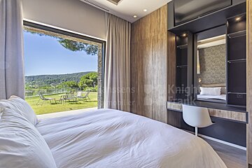 A bedroom with a large bed and a knight frank logo on the wall
