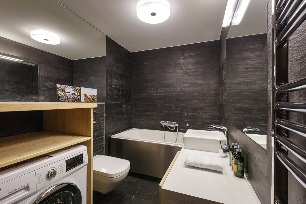 A bathroom with a washing machine and a sink