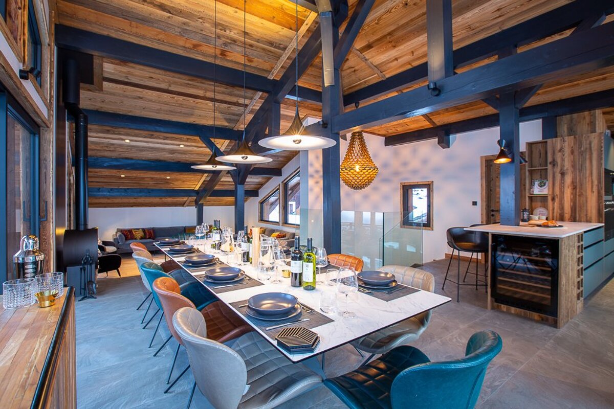 A long dining table with plates and wine bottles on it