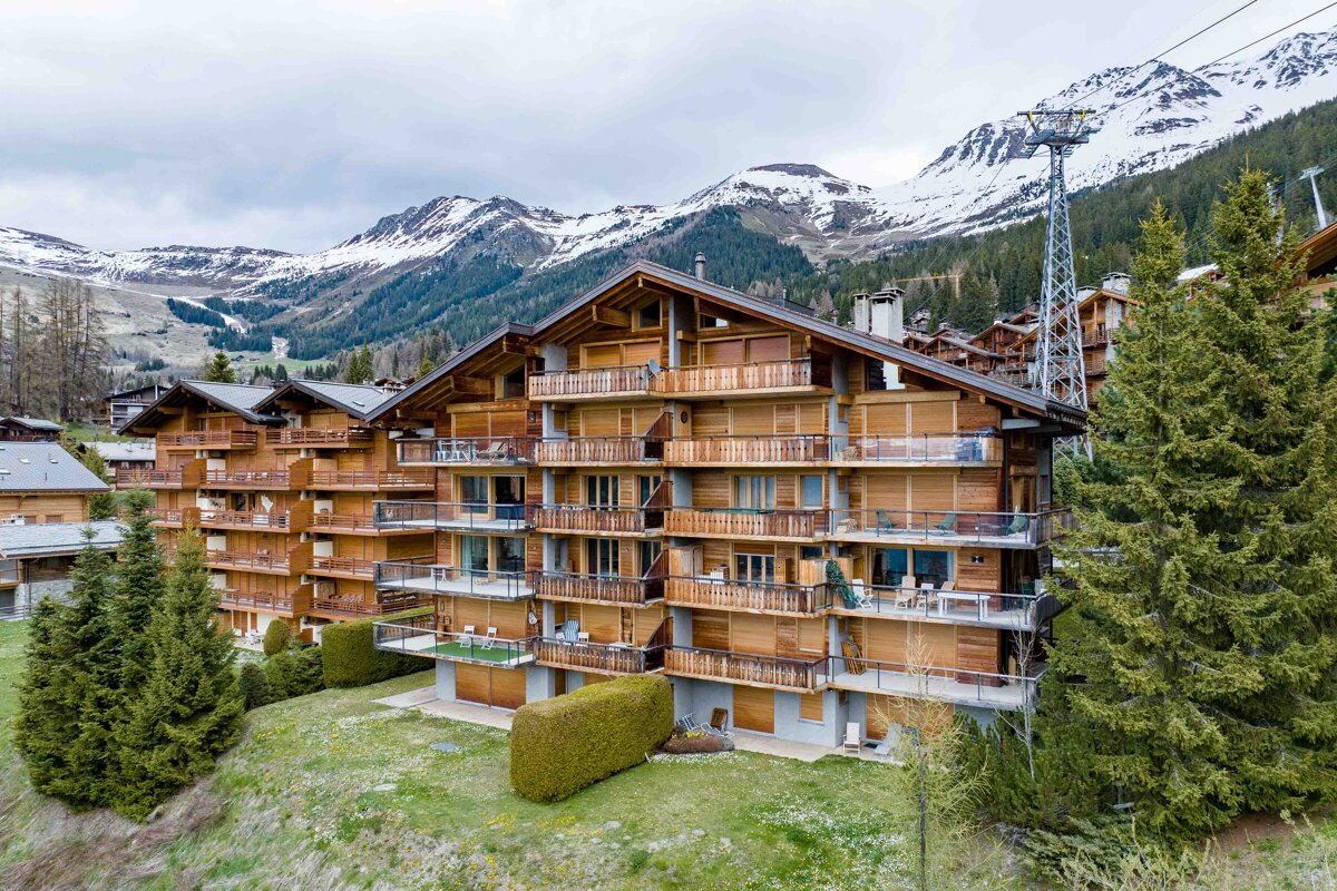 A building with a lot of balconies and mountains in the background