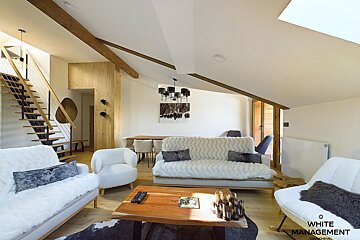 A living room with white management written on the bottom