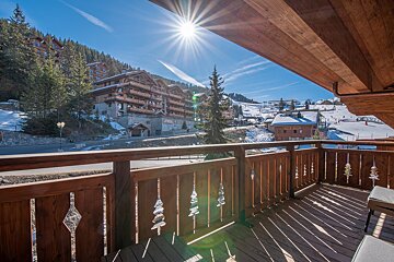 A balcony with a view of a ski resort with a sign that says ' hotel ' on it