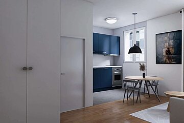A modern apartment featuring a blue kitchen, a dining area with a round wooden table, and sleek white walls with a dark painting.