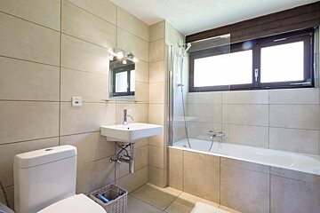 A bathroom with a toilet a sink and a bathtub