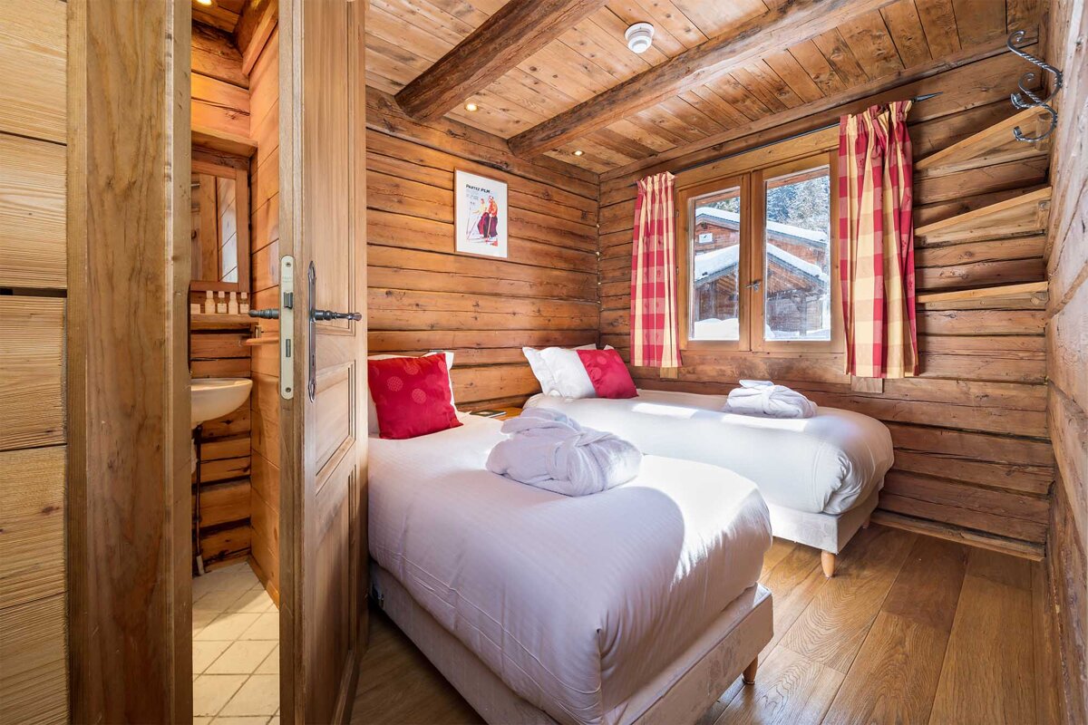 A bedroom in a log cabin with two twin beds