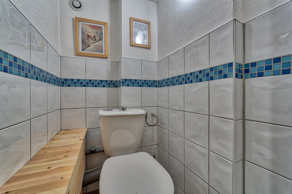 A toilet in a bathroom with a framed picture on the wall above it