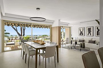 Bright, modern dining and living room with a sea view balcony. Features neutral tones, minimalist furniture, and abstract art.