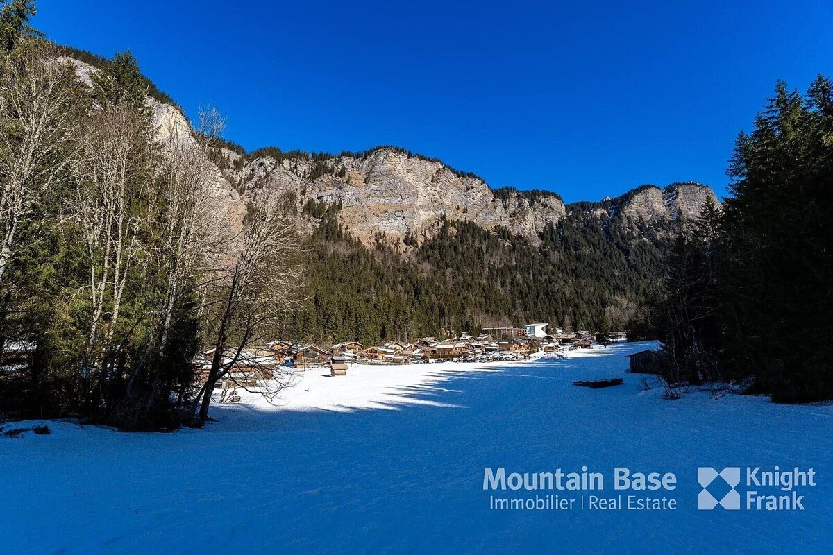 A snowy landscape with the words mountain base knight frank on the bottom