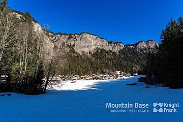 A snowy landscape with the words mountain base knight frank on the bottom