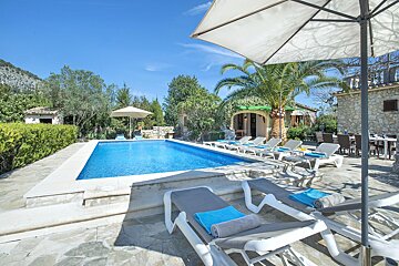 A large swimming pool surrounded by chairs and umbrellas