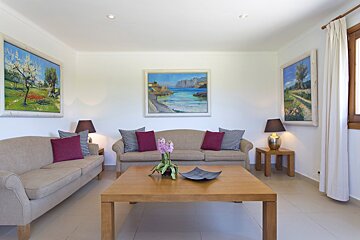 A dining room with a table and chairs and a painting on the wall