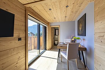 A room with wood paneling and a desk and chair