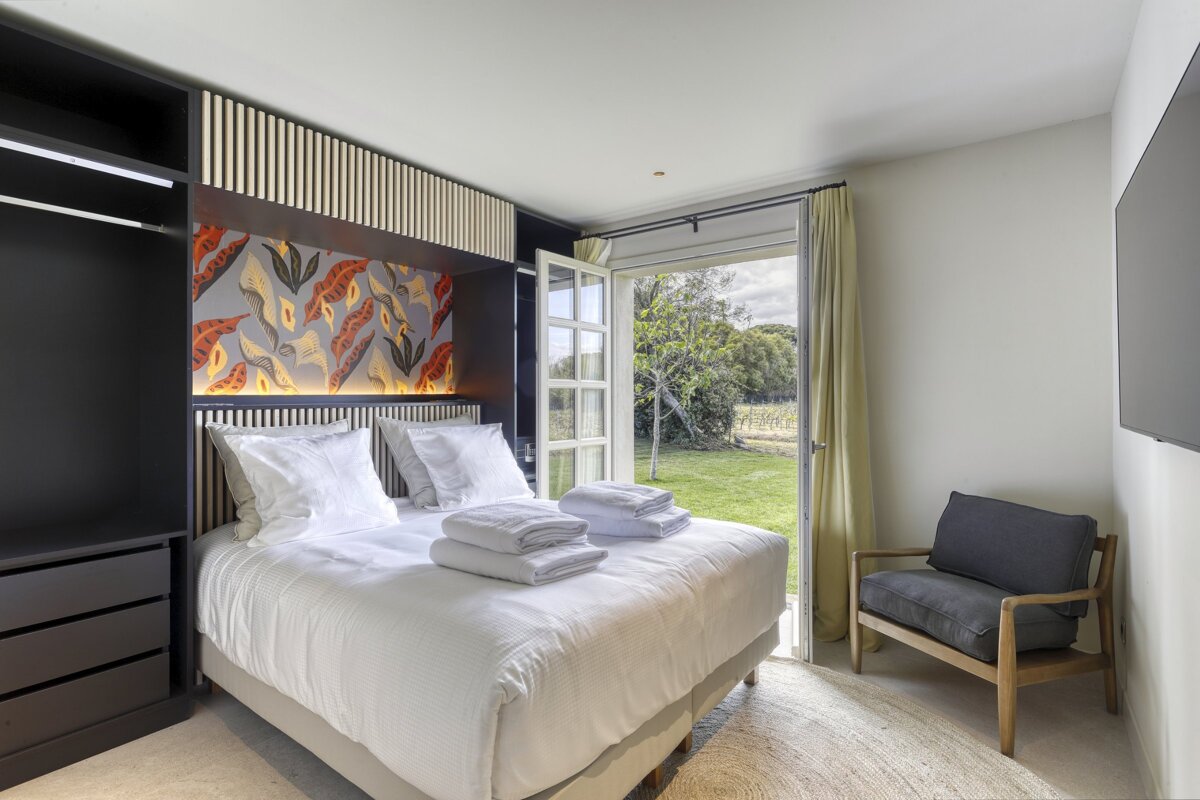 A bedroom with a large bed and a chair