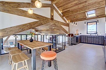 A kitchen with a wooden table and stools