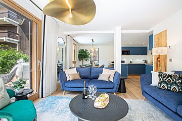 A living room with a blue couch and a black coffee table
