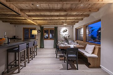 A dining room with a wooden table and chairs