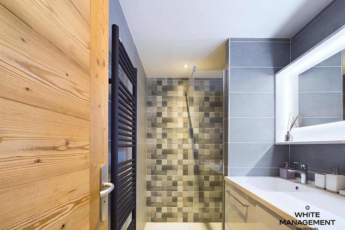 A bathroom with a white management logo on the wall