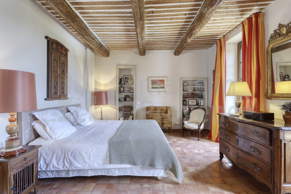 A bedroom with a large bed and a dresser