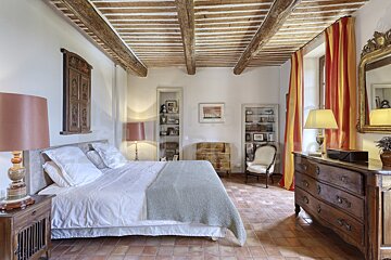 A bedroom with a large bed and a dresser