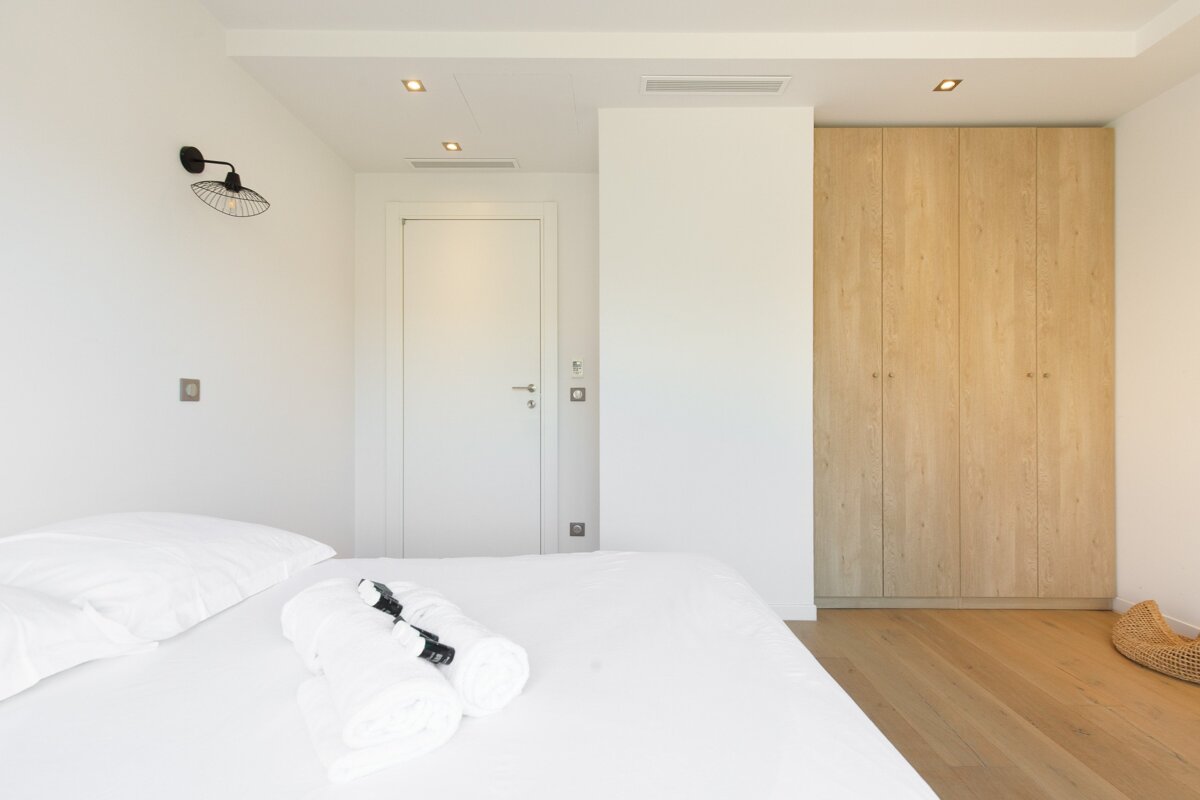 A bedroom with a white door and wooden cabinets