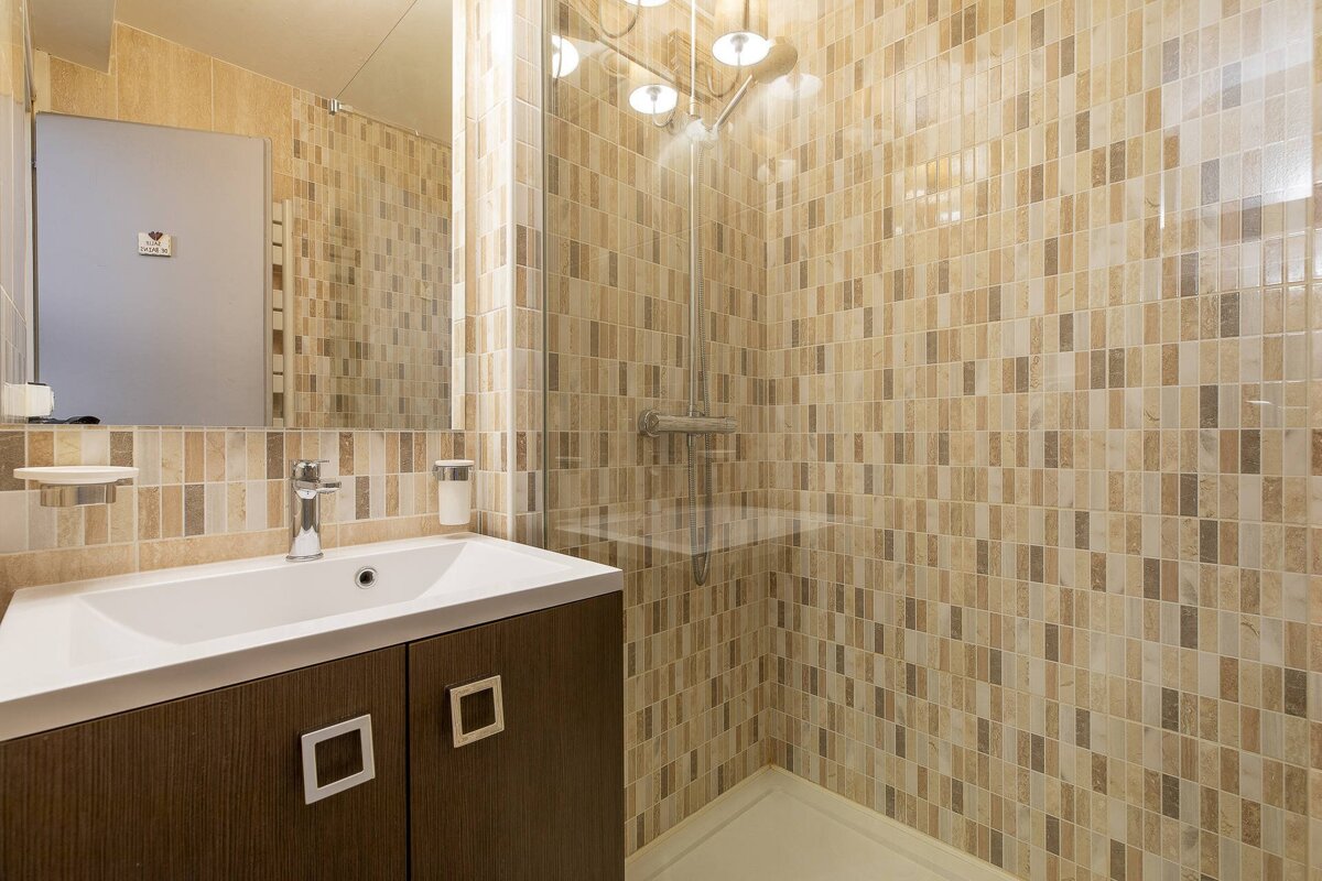 A kitchen with red cabinets and a clock that says 12:05