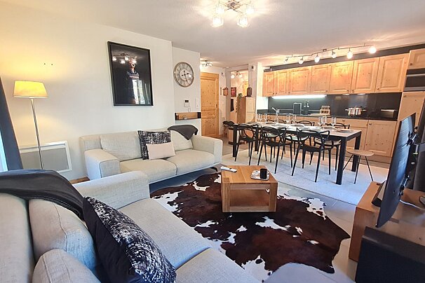 A living room with a cowhide rug and a clock on the wall