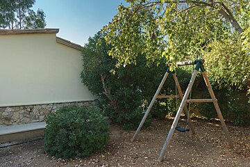 A wooden swing set in front of a house