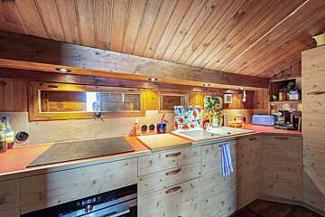 A kitchen with wooden cabinets and a stove top oven