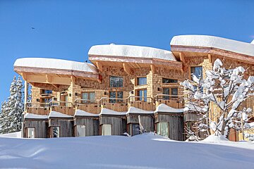 A row of wooden houses with snow on the roofs