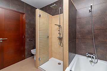 A bathroom with a walk in shower and a bathtub