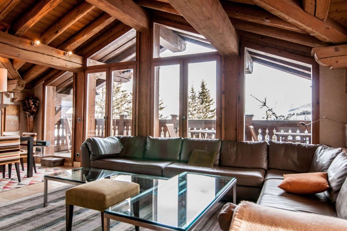 A living room with a large sectional couch and a glass coffee table