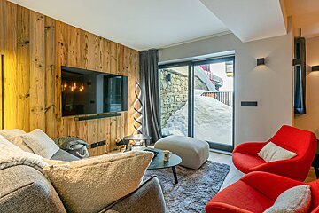 A living room with a large flat screen tv on the wall