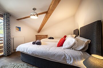 A bedroom with two beds and a painting on the wall