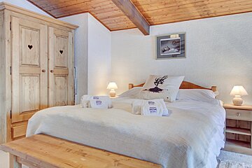A bedroom with a bed and a picture on the wall