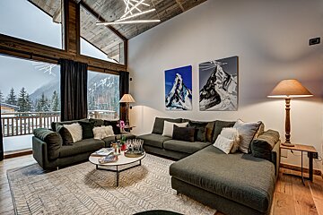A living room with two paintings of mountains on the wall