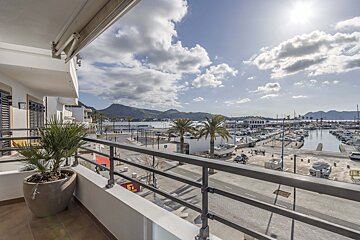 A balcony with a view of a marina and mountains