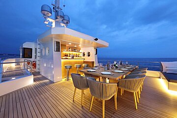 A boat with a table and chairs and a bar