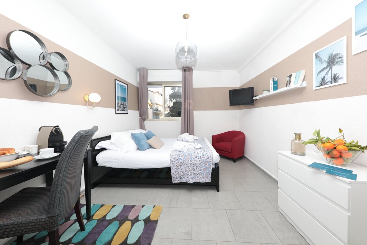 A bedroom with a single bed a chair and a dresser